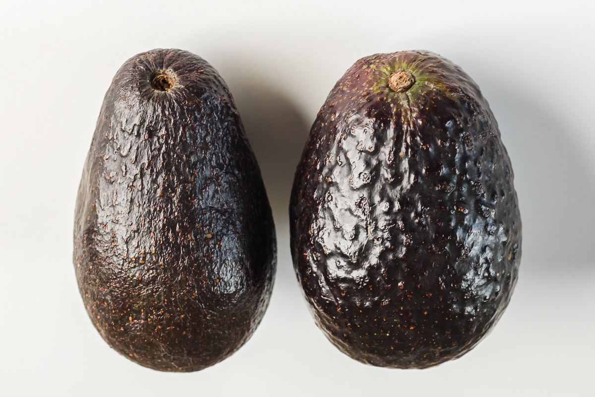 A ripe avocado sits prominently, flanked by a flurry of diced