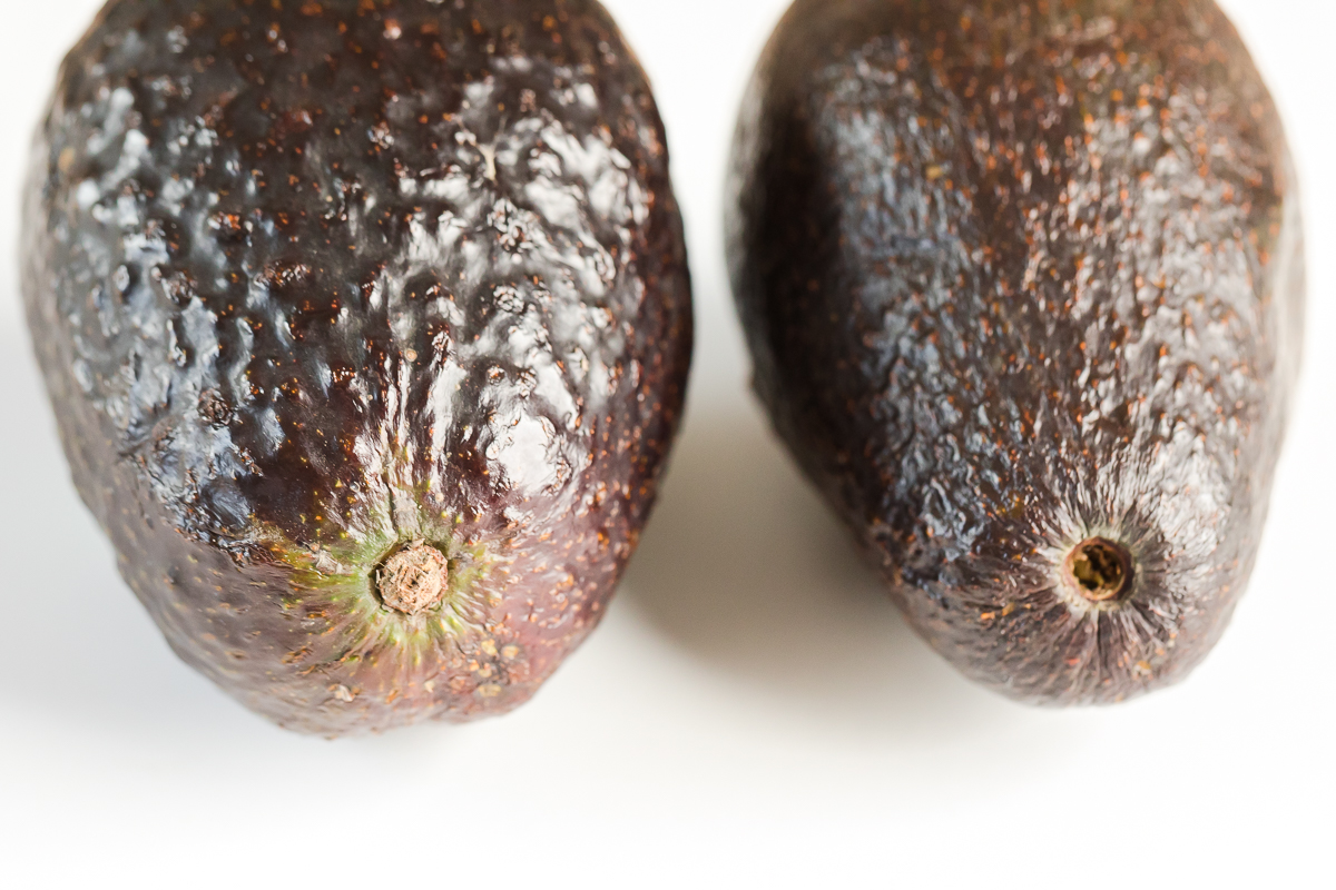 how to pick an avocado with stem showing left with stem and right avocado brown inside missing stem from purchase.