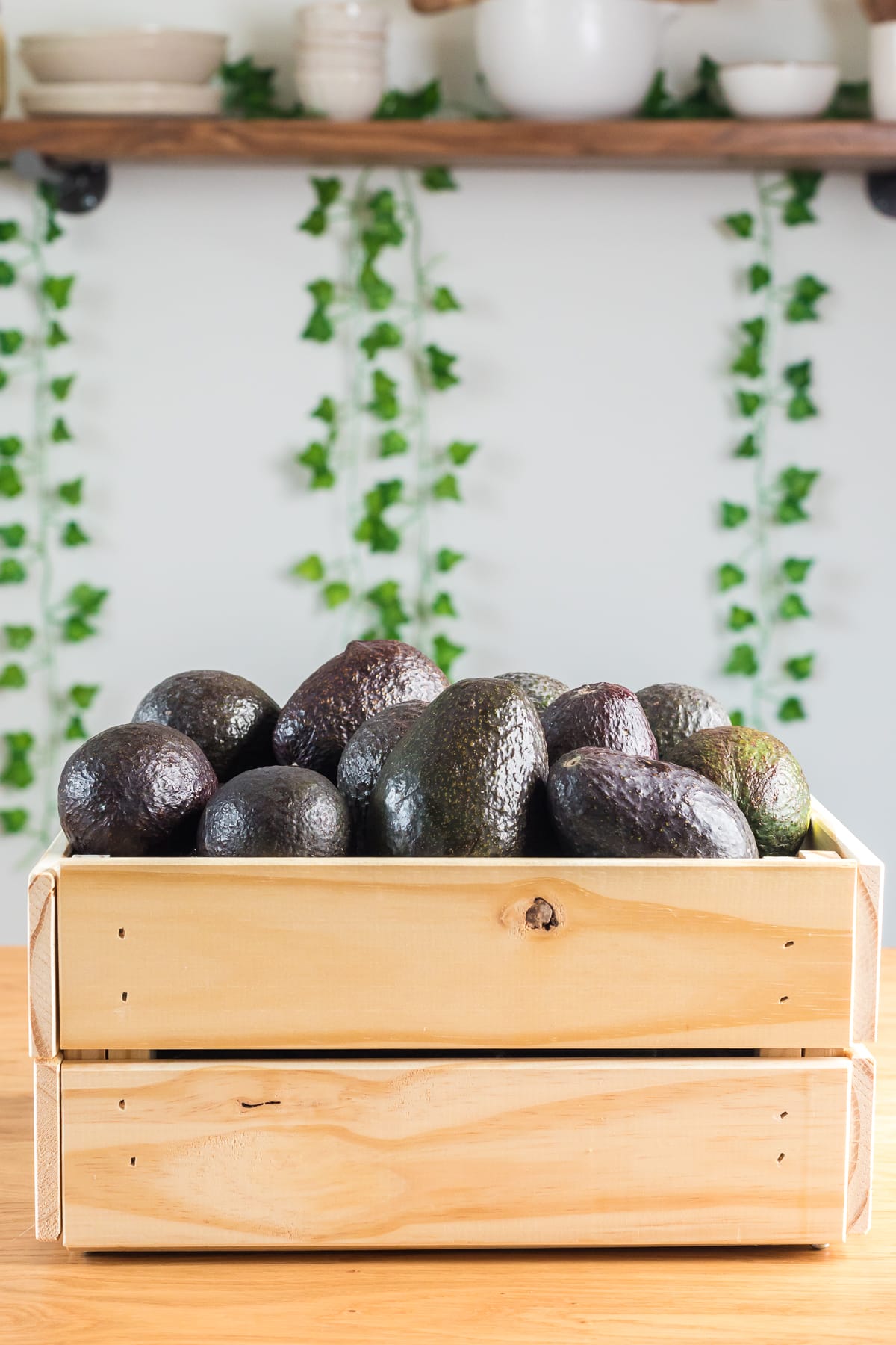 crate filled with ripe avocados.