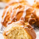 close up of cut in half peach fritter with whole ones behind it.