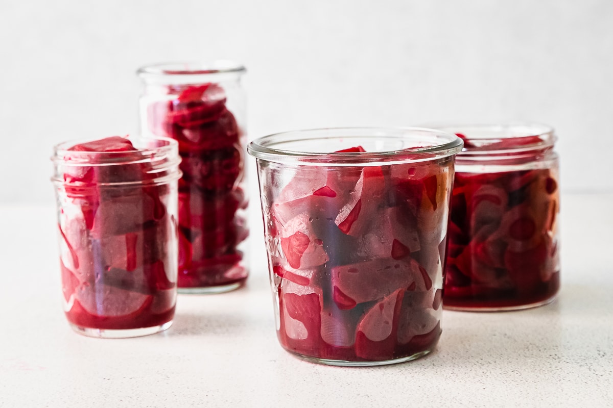 various glass jars filled with chopped and sliced beets.