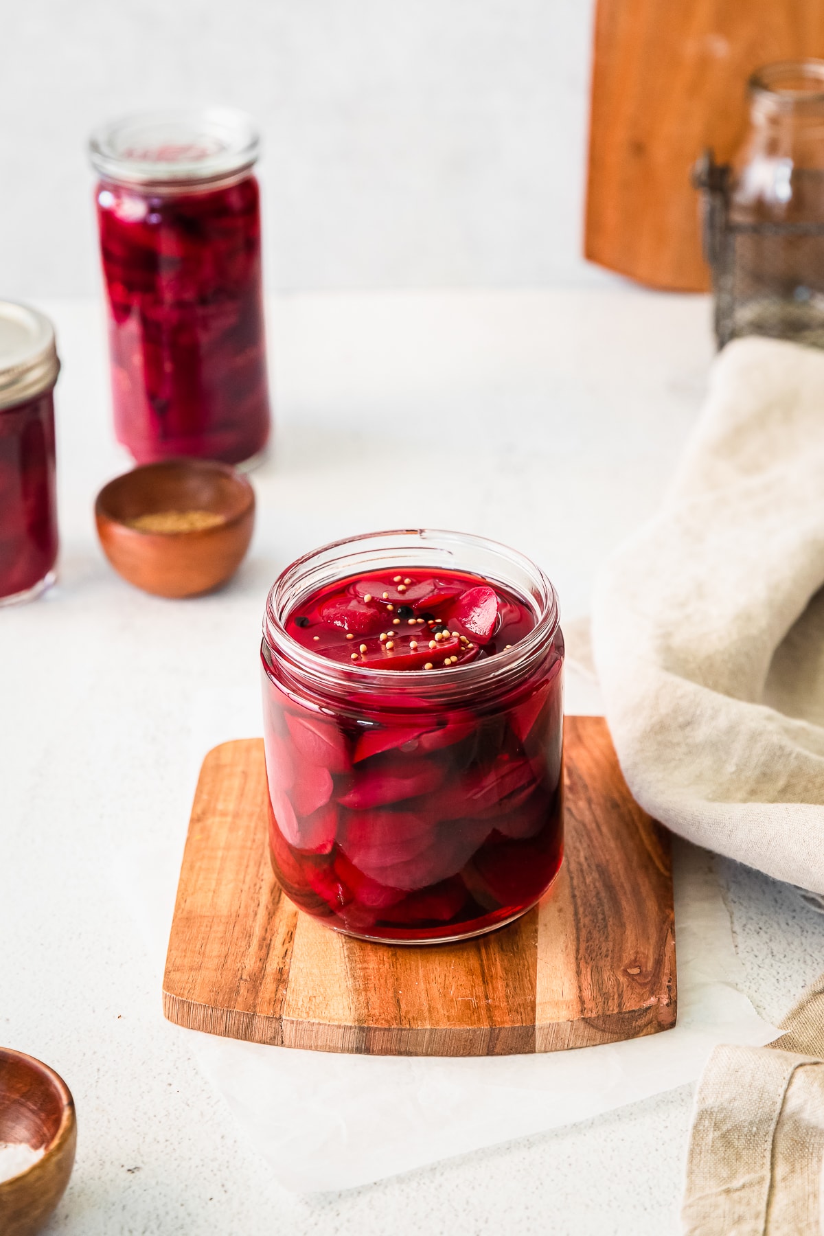 quick pickled beets in a glass jar on a cutting board.