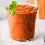 roasted tomato sauce in a glass jar with basil garnish