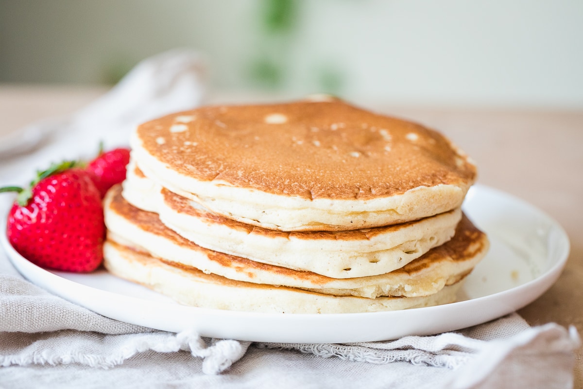 stack of dairy free pancakes on a white plate.