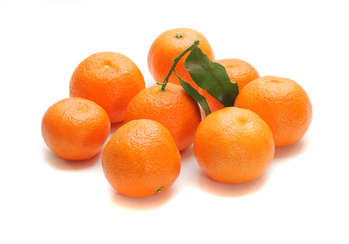 mandarin oranges on a white background one with a stem and leaves.