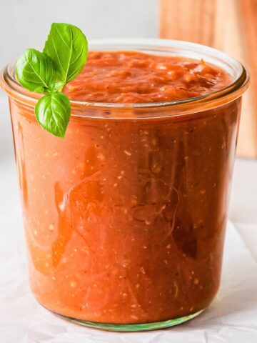 roasted tomato sauce in a glass jar with basil garnish