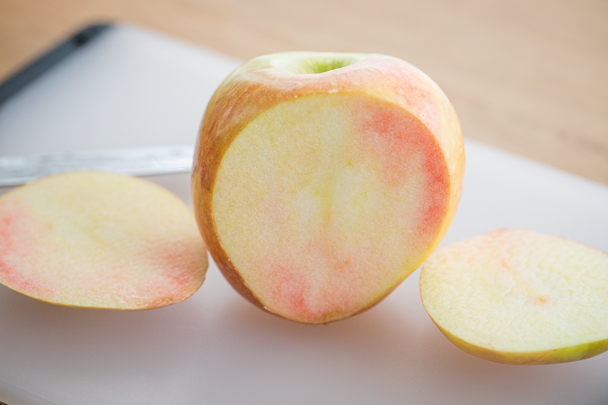 inside of a lucy glo apple showing pink flesh.