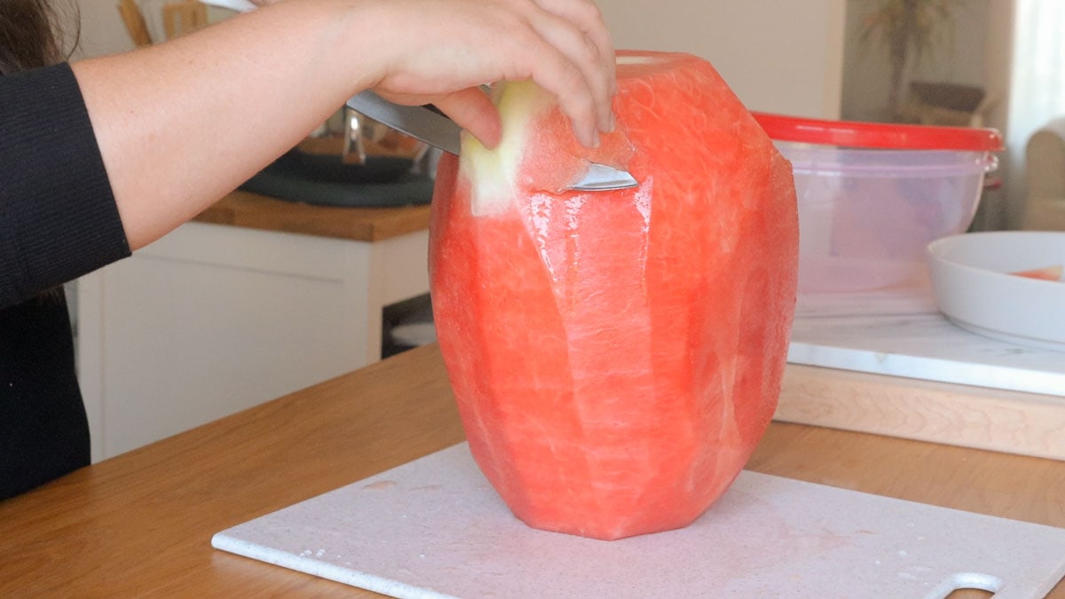 removing white from a watermelon while cutting.