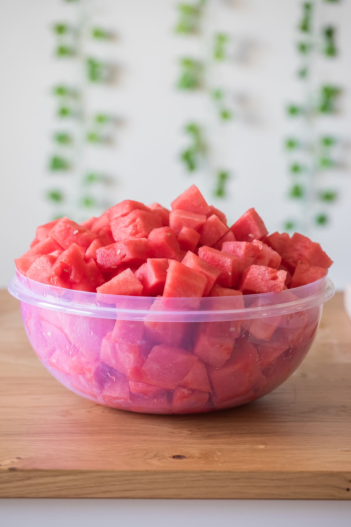 how to cut watermelon showing watermelon chunks in a large bowl.