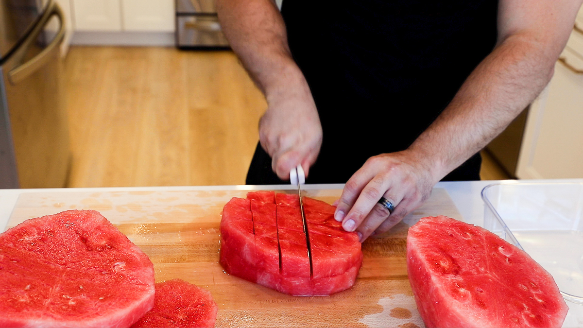 slicing watermelon into strips the other way creating chunks.