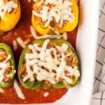 overhead photo of stuffed peppers in a white casserole dish.
