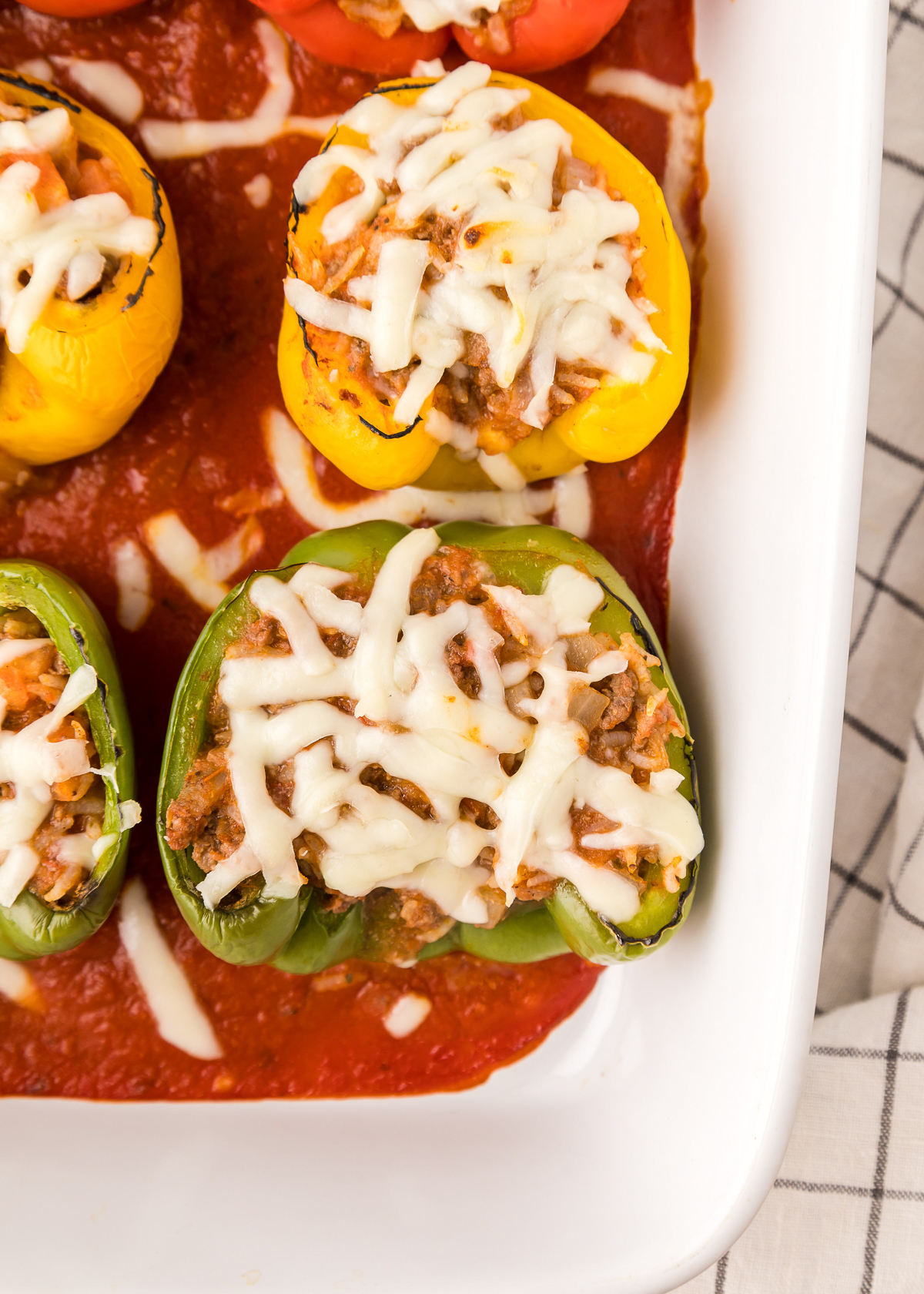 overhead photo of stuffed peppers in a white casserole dish.