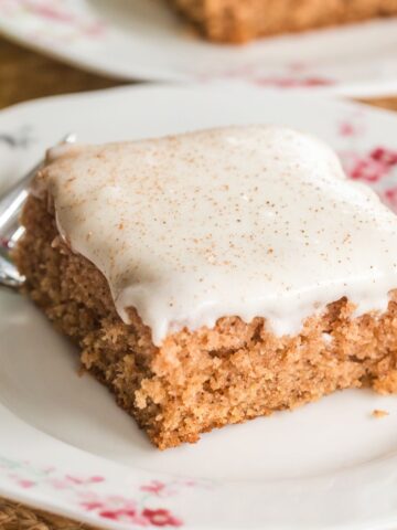 applesauce cake with cream cheese frosting on a plate.