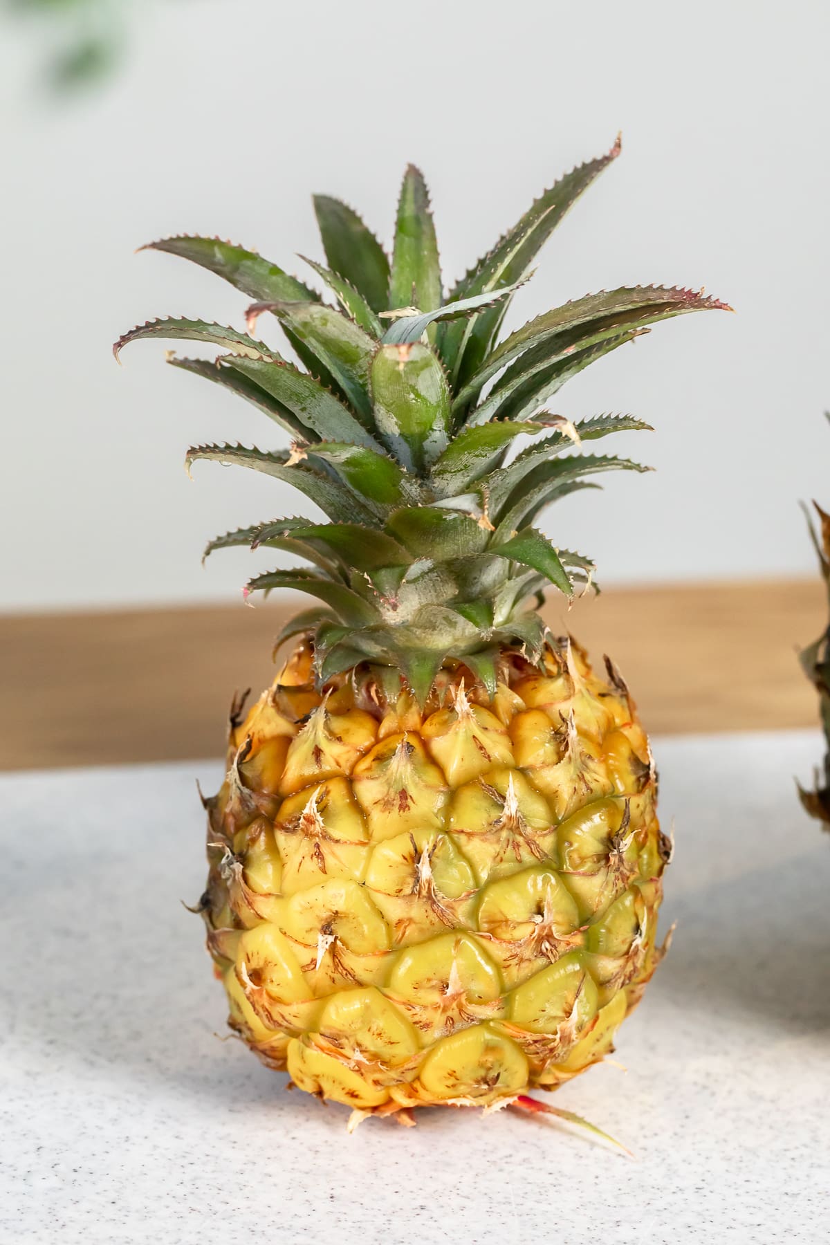 baby pineapple on a cutting board.