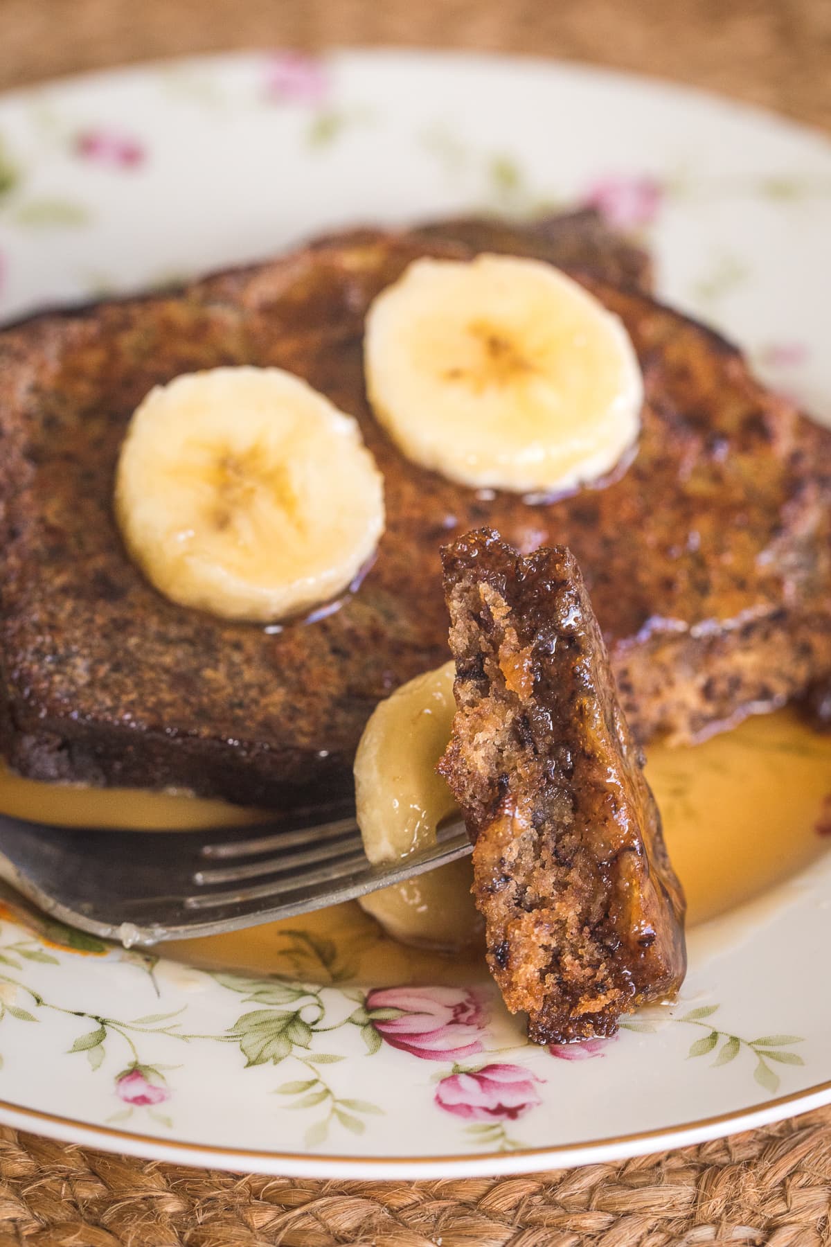 banana bread french toast on ap late with a fork showing one bite.