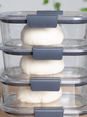 homemade pizza dough in airtight containers stacked ready for the fridge.