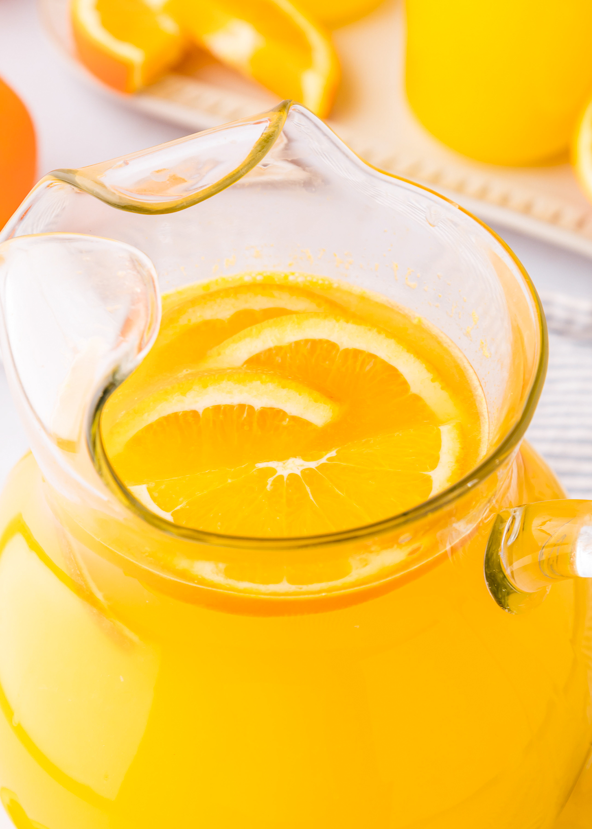 close up of fresh orangeade in a glass pitcher.