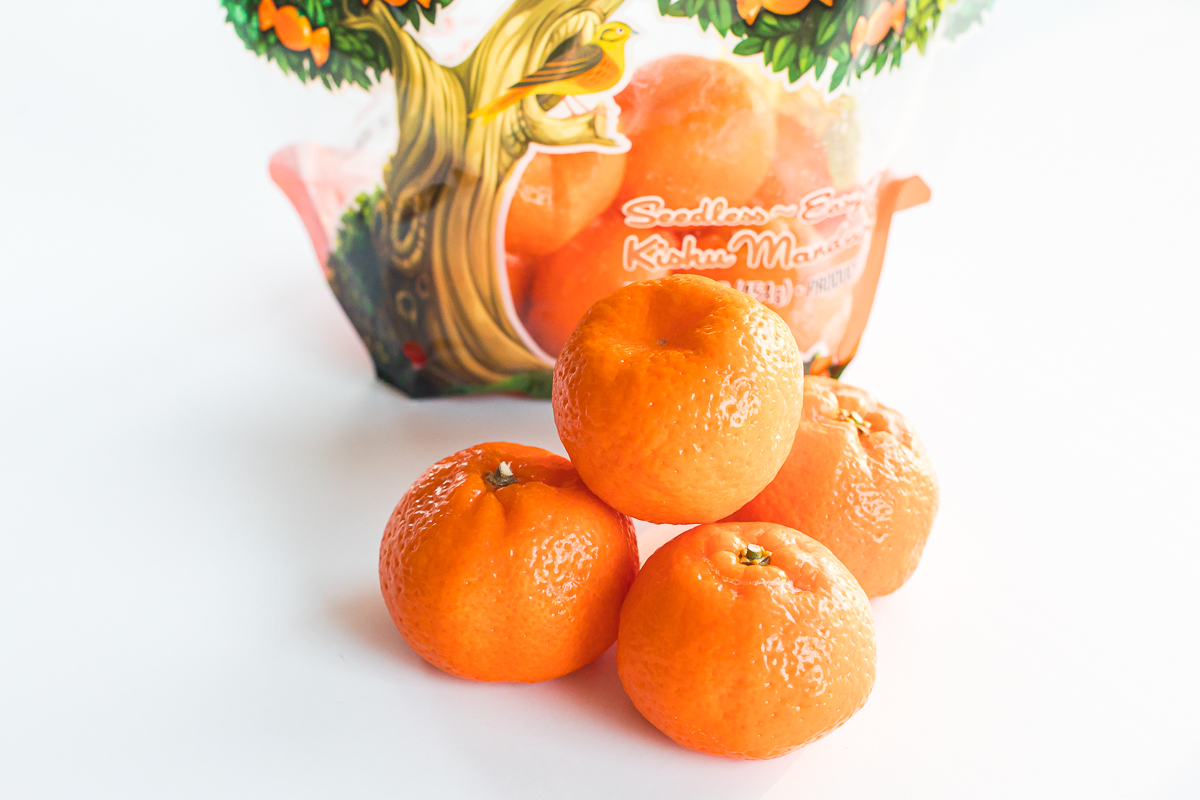 Kishu Mandarins, 4 stacks, in front a bag of mandarins.