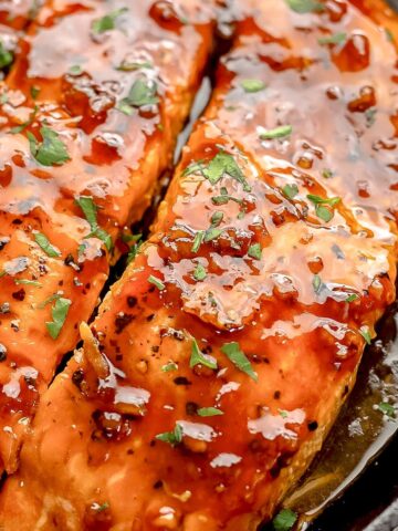 honey garlic salmon on a cast iron skillet.