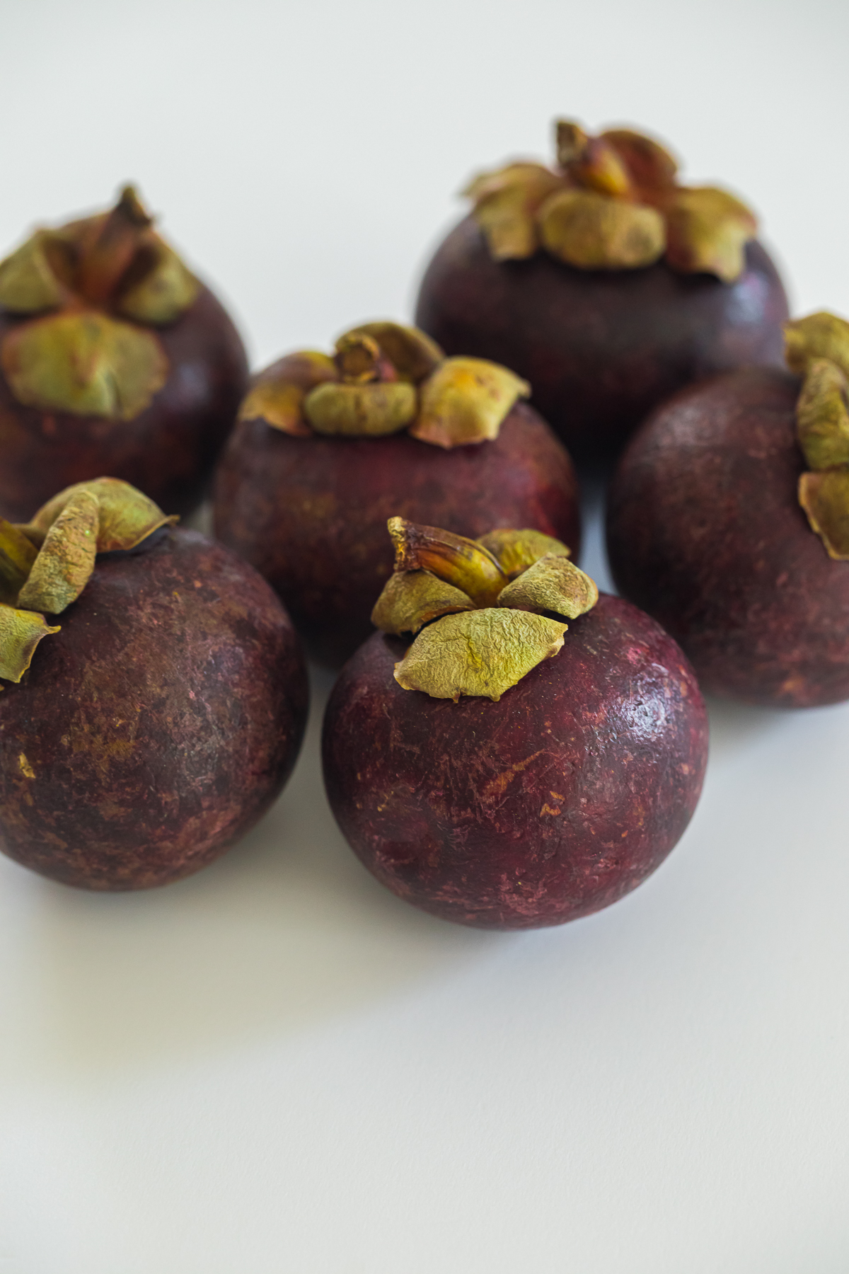 6 mangosteens on a white board.