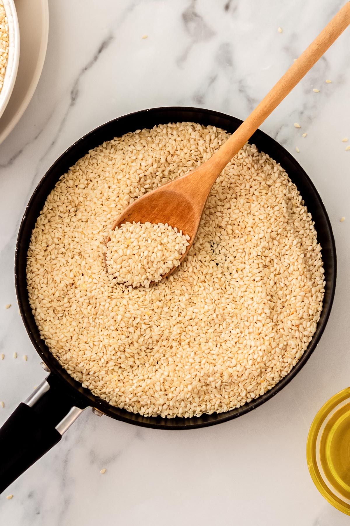 sesame seeds in a pan with a spoon.