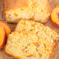 two slices of peach bread in front of the loaf of peach bread.