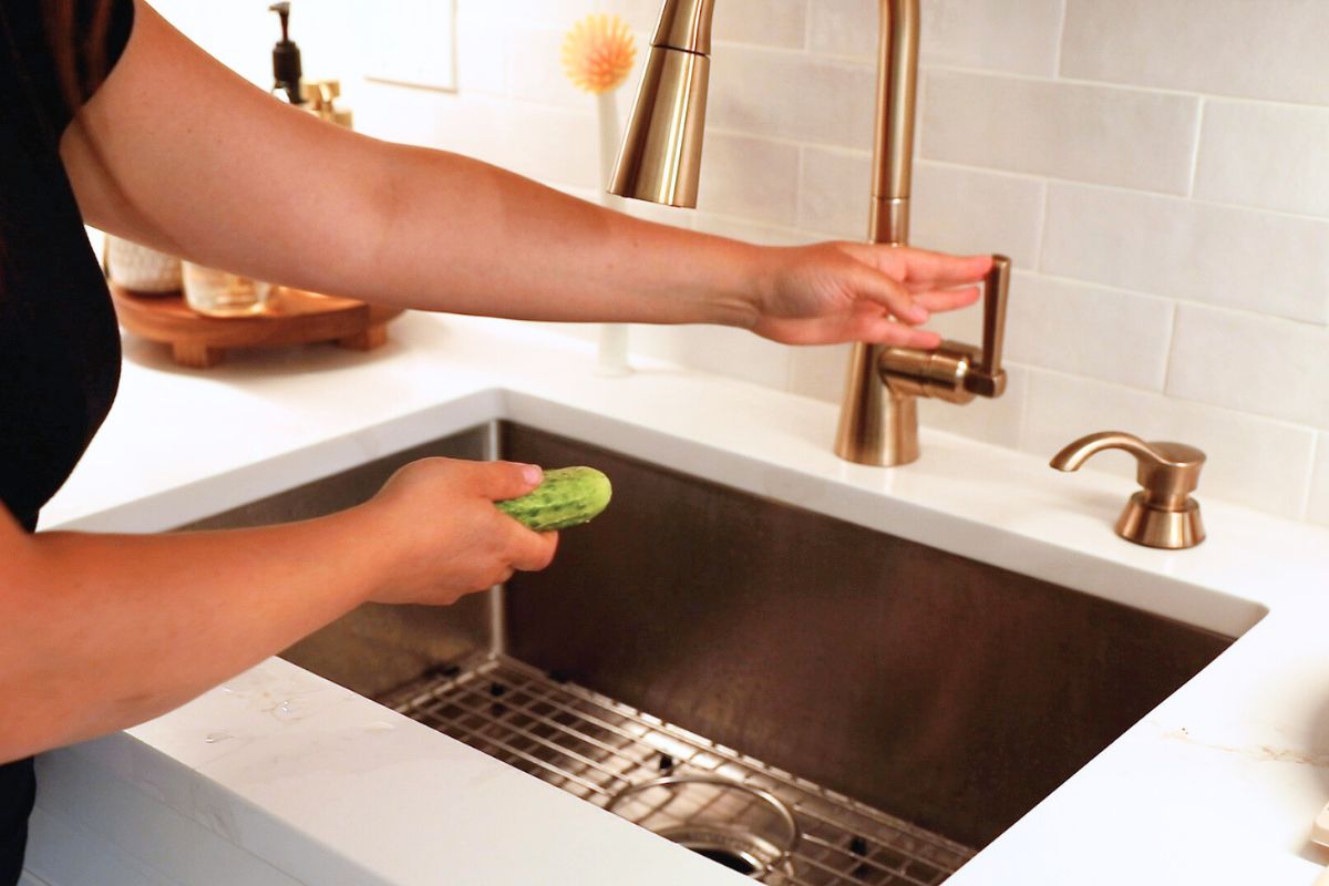 washing cucumbers in kitchen sink.
