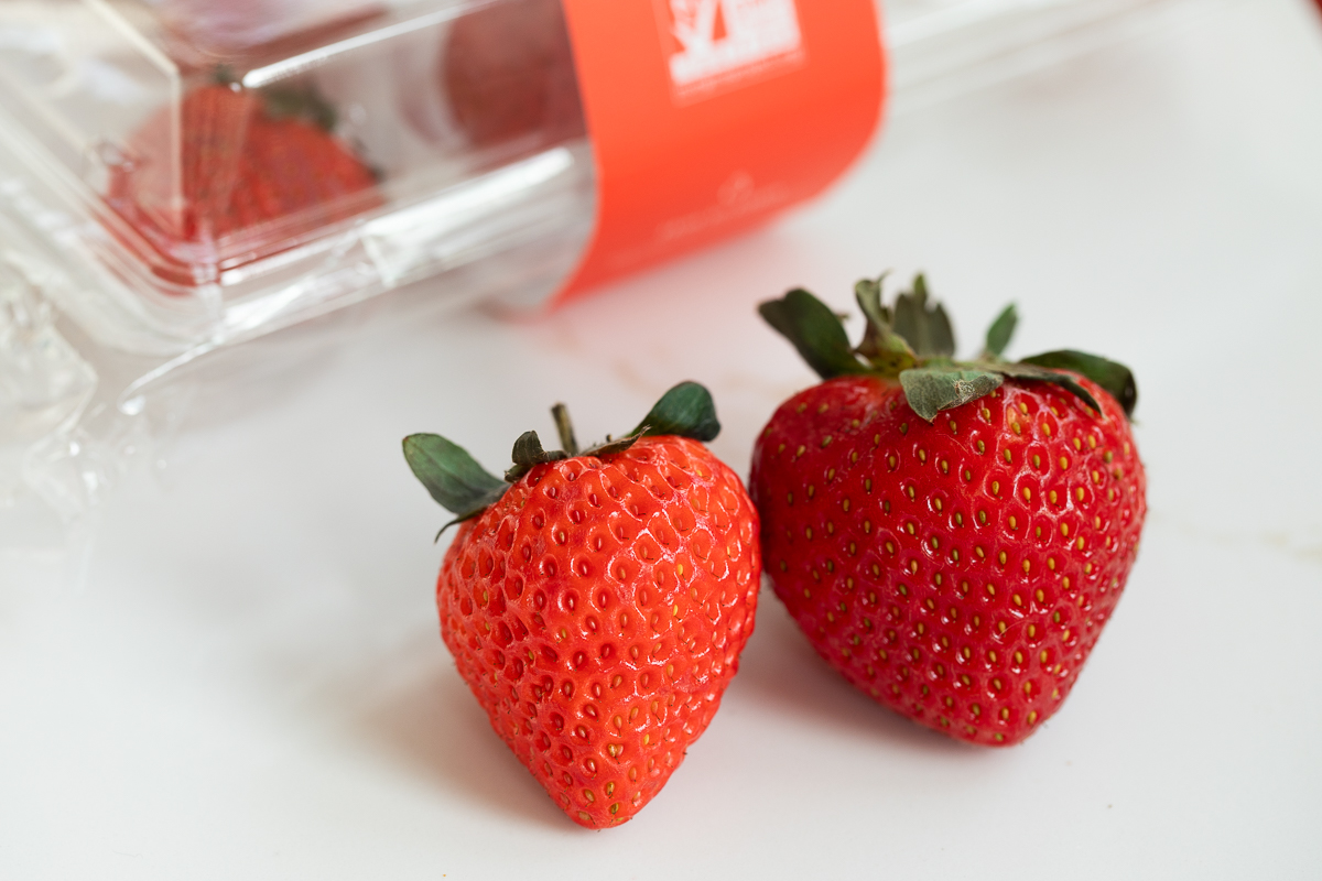 oishii strawberry next to a driscoll strawberry.