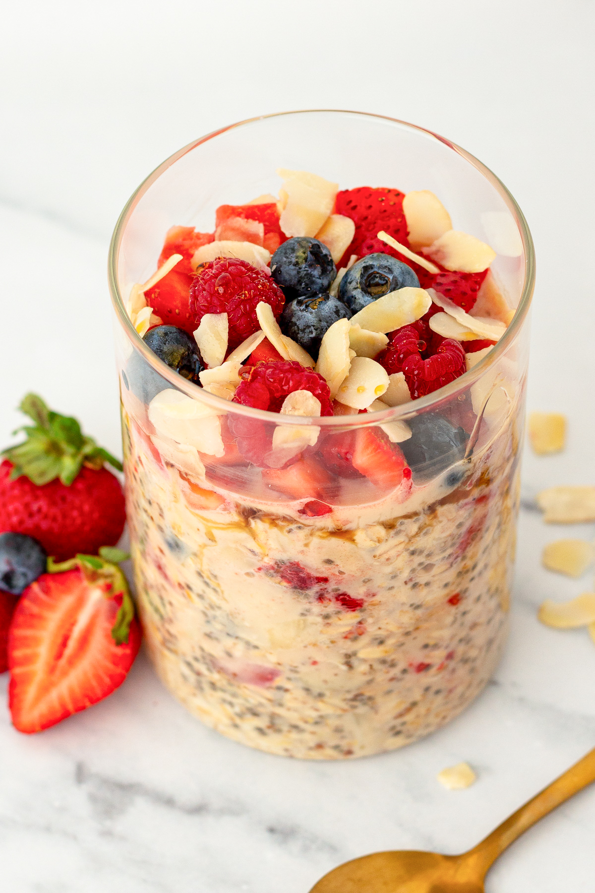 triple berry overnight oats with slivered almonds in a glass jar.