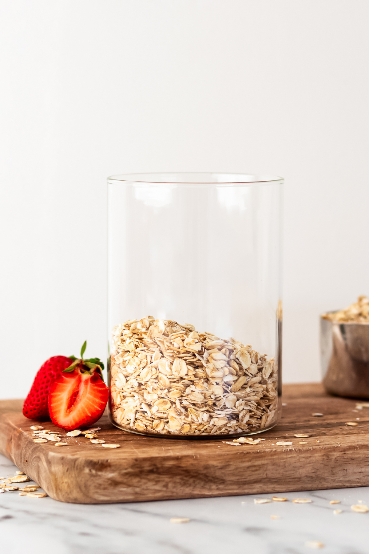 oats in a glass jar on a cutting board.
