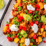 totchos on a baking sheet with tons of nacho toppings.