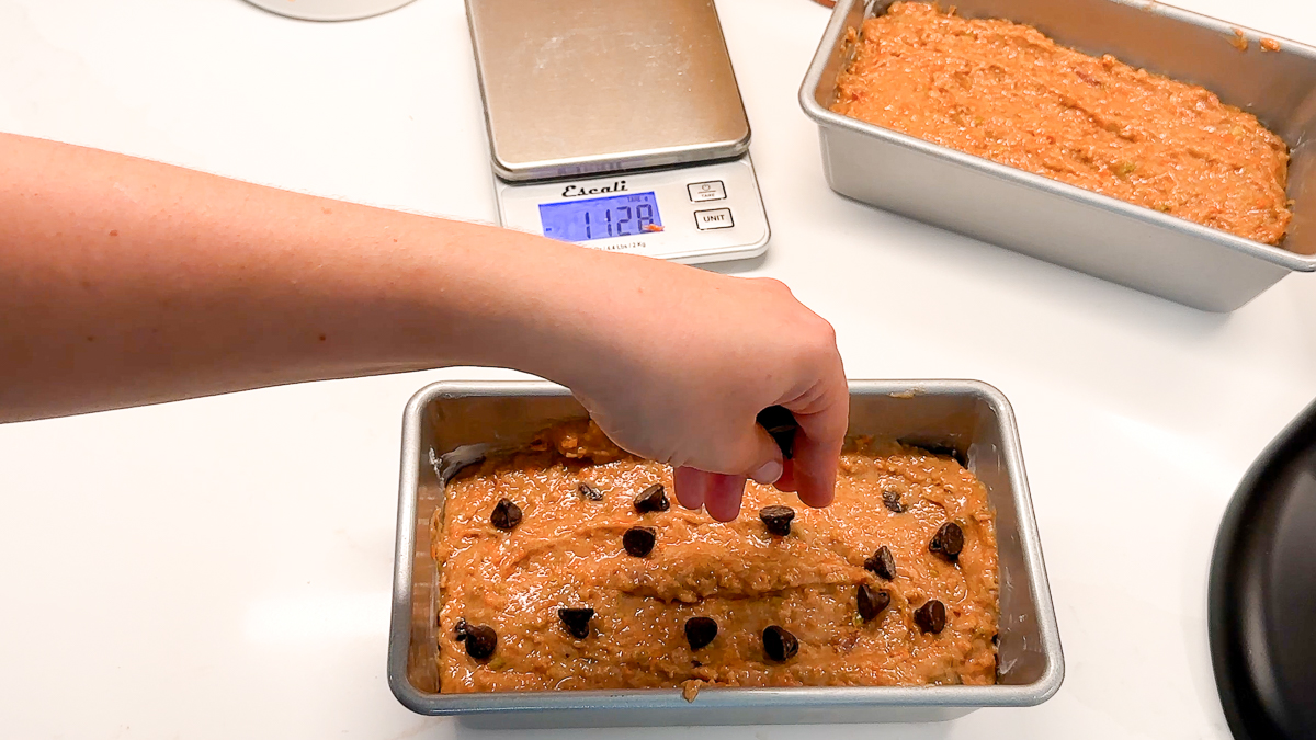 adding chocolate chips to top of apple carrot bread.