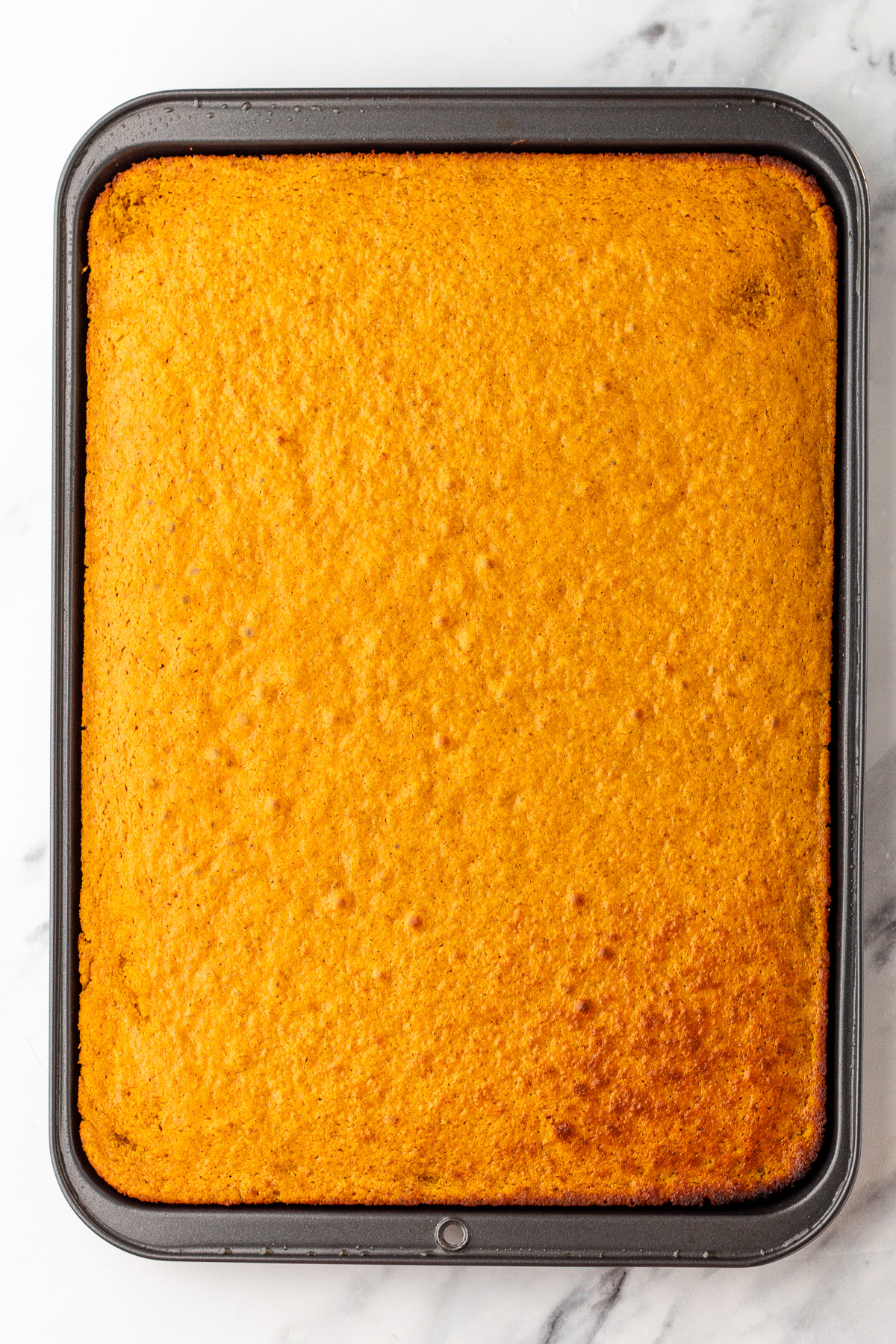 baked pumpkin roll cake in pan.